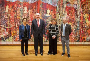 Full-length photo portrait of collector and Nasher Museum Board of Advisors Chair Nancy A. Nasher (left), who poses in front of a work by Elliott Hundley with her husband David J. Haemisegger, Nasher Museum Director Sarah Schroth and Marshall N. Price, Nancy Hanks Curator of Modern and Contemporary Art. Photo by J Caldwell.