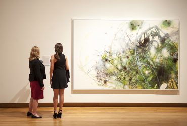 Two visitors take a close look at Matthew Ritchie's work, Link of Nature, oil and ink on canvas. Photo by J Caldwell.