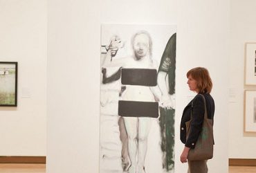 A visitor strolls past a work by Marlene Dumas. Photo by J Caldwell.