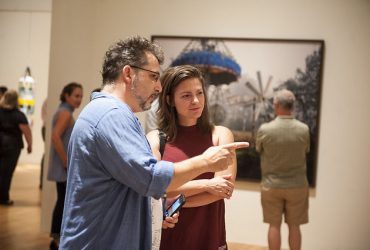 Durham artists Chris Vitiello (left) and Stephanie Leathers talk about the work in the gallery. Photo by J Caldwell.