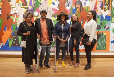 Nina Chanel Abney poses with family and friends in an exhibition gallery. Photo by J Caldwell.