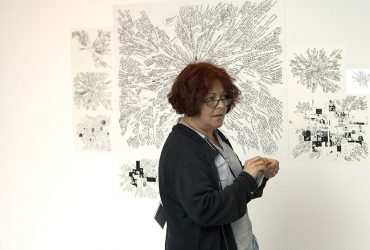 Lia Perjovschi installs her work, em>Mind Map (Diagram), on the lecture hall wall at the Nasher Museum. Photo by Duke Photography.