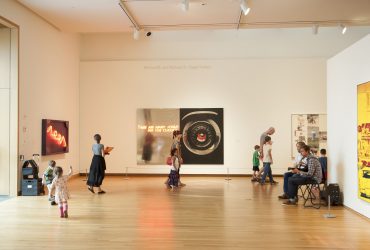During a Free Family Day event, families visit a gallery featuring works by Robert Rauschenberg and other artists. Photo by J Caldwell.