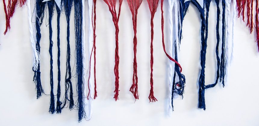 Sonya Clark, Unraveling, 2015–present. Cotton Confederate battle flag and unraveled threads, edition 2/10; 70 x 36 x 7 inches (177.8 x 91.4 x 17.8 cm). Courtesy of the artist. © Sonya Clark. Photo by J Caldwell
