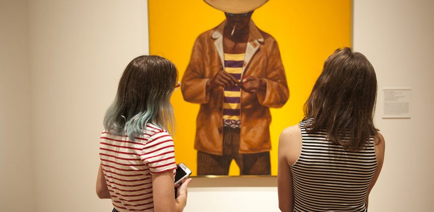 Visitors enjoy a painting by Barkley L. Hendricks, Down Home Taste, part of the exhibition Southern Accent: Seeking the American South in Contemporary Art. Photo by J Caldwell.