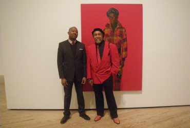 Dr. Kenneth Montague (left) poses with Barkley L. Hendricks in front of Blood (Donald Formey), a painting created by Barkley in 1975, which Montague purchased for his contemporary collection, The Wedge Collection. Photo by J Caldwell.