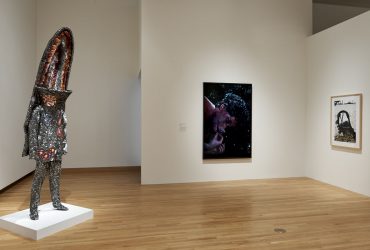 This installation view of All Matterings of Mind features a work by Nick Cave, Soundsuit, on the left, with (left to right) works by Cindy Sherman and Zhang Dali in the gallery. Photo by Peter Paul Geoffrion.