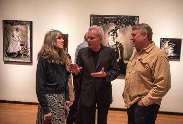 Alex Harris (center) chats with visitors in the gallery.