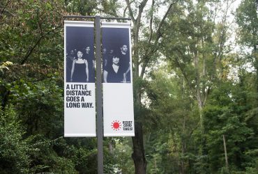 A RESIST COVID / TAKE 6! street pole banner at the Nasher Museum, facing Duke University Road. Courtesy of Carrie Mae Weems. Photo by J Caldwell.
