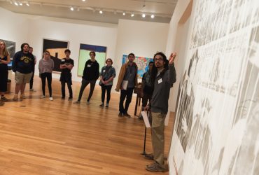 Gallery guide Bakari Roscoe leads a tour of Art for a New Understanding with local high schoolers
