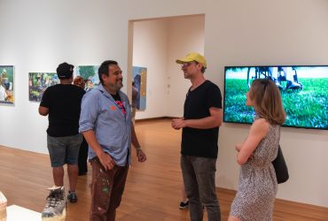 Reckoning and Resilience artist Renzo Ortega chats with visitors