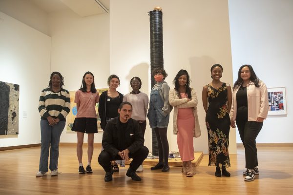 Artist William Cordova strikes a pose with Nasher Teens in front of his work "Greatest Hits (para Micaela Bastidas, Tom Wilson y Anna Mae Aquash) [(for Micaela Bastidas, Tom Wilson and Anna Mae Aquash)]," a sculpture made of 3,000 records.
