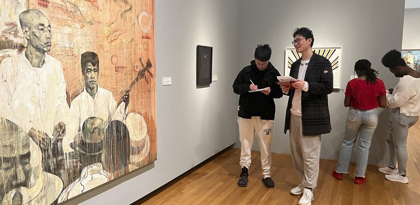 Two Duke Students admire artist Hung Liu's 2000 work of art "Storyteller."